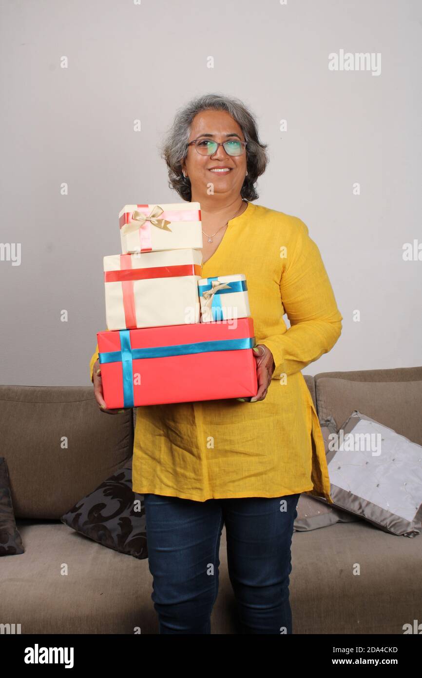 Portrait d'une femme indienne heureuse tenant une pile de cadeaux. Banque D'Images