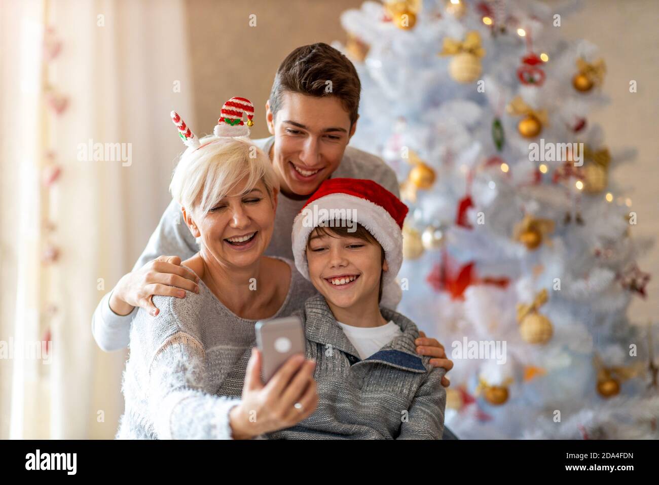 Mère et fils prenant le selfie à une fête de Noël à accueil Banque D'Images