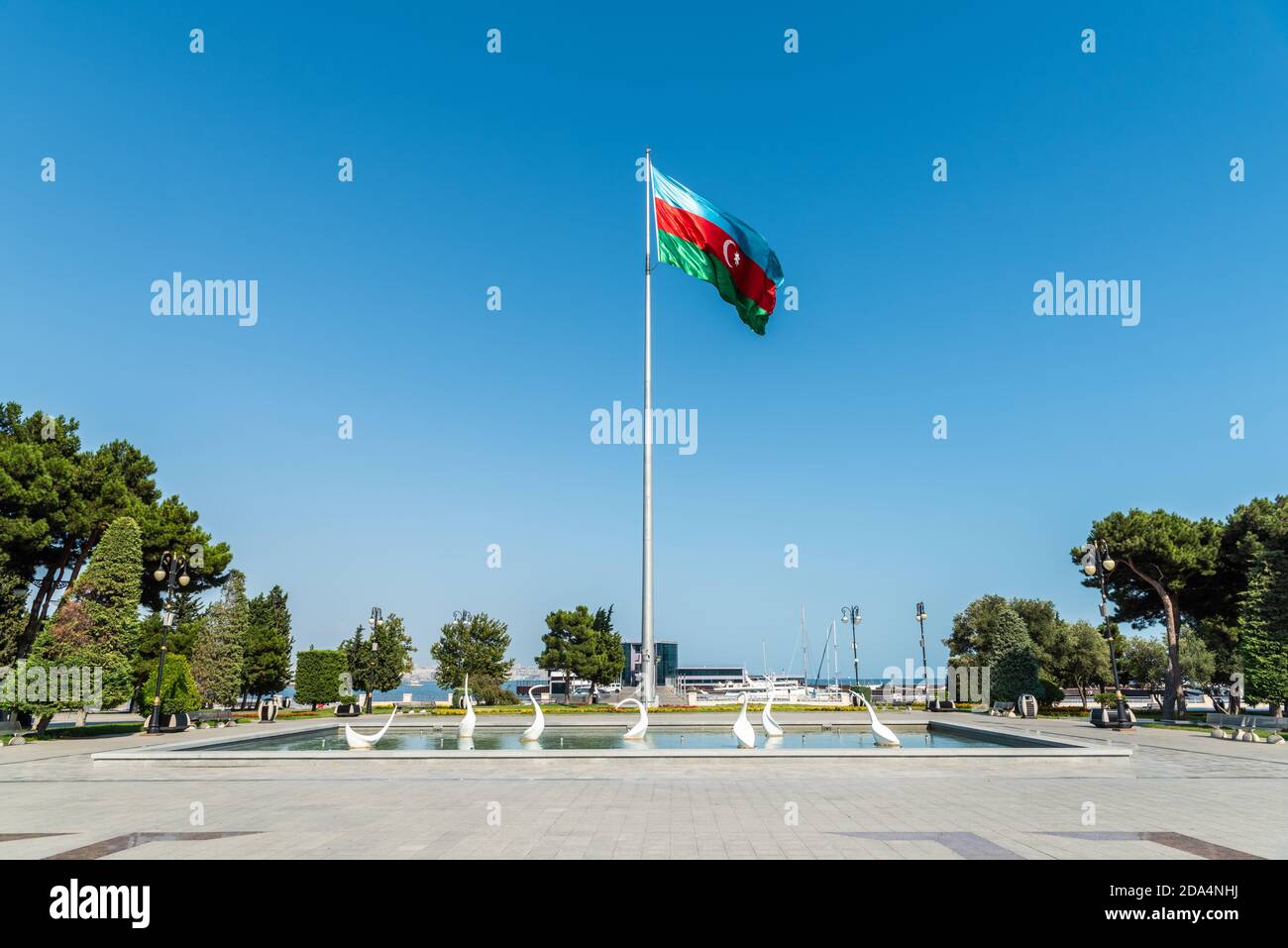 Bakou, Azerbaïdjan – 2 août 2020. Étang avec sculptures de cygne et drapeau national de l'Azerbaïdjan sur le boulevard de bord de mer à Bakou. Banque D'Images