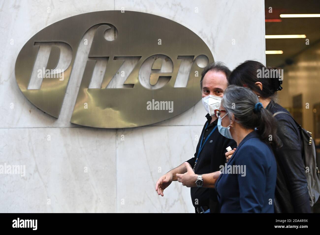 Les gens dépassent le siège mondial de Pfizer après que le fabricant de médicaments a annoncé que les premiers tests sur son vaccin expérimental COVID-19 étaient efficaces à 90 % et pourraient être disponibles d'ici la fin de l'année, New York, NY, le 9 novembre 2020. Alors que les États-Unis ont établi une vague record de cas de coronavirus, le Dow Jones s'est envolé dans les premières négociations sur les nouvelles de l'efficacité du vaccin, bien qu'il ait été signalé qu'environ 50 millions de doses seulement seraient disponibles au début et seraient distribuées aux travailleurs de la santé et aux personnes les plus exposées au risque de contracter le coronavirus. (Anthony Behar/Sipa États-Unis) Banque D'Images