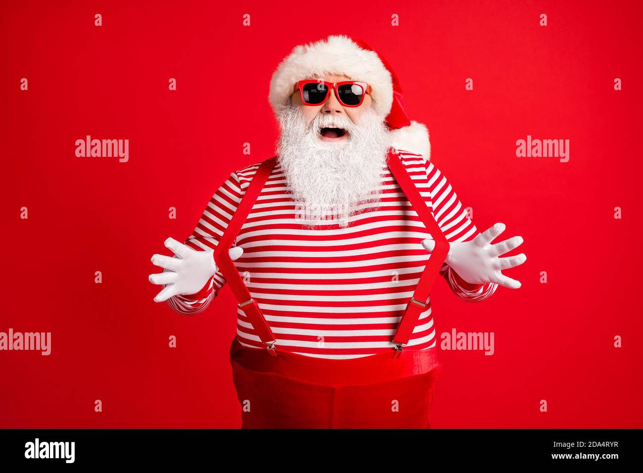 Portrait de son il beau beau comique attrayant childish gai Tricherie à  cheveux gris père Noël portant des gants ayant le plaisir de tirer des  bretelles isolées Photo Stock - Alamy
