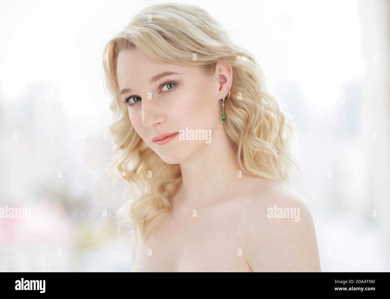 Belle jeune femme souriante avec belle coiffure et bonne peau sur fond clair, portrait de beauté Banque D'Images