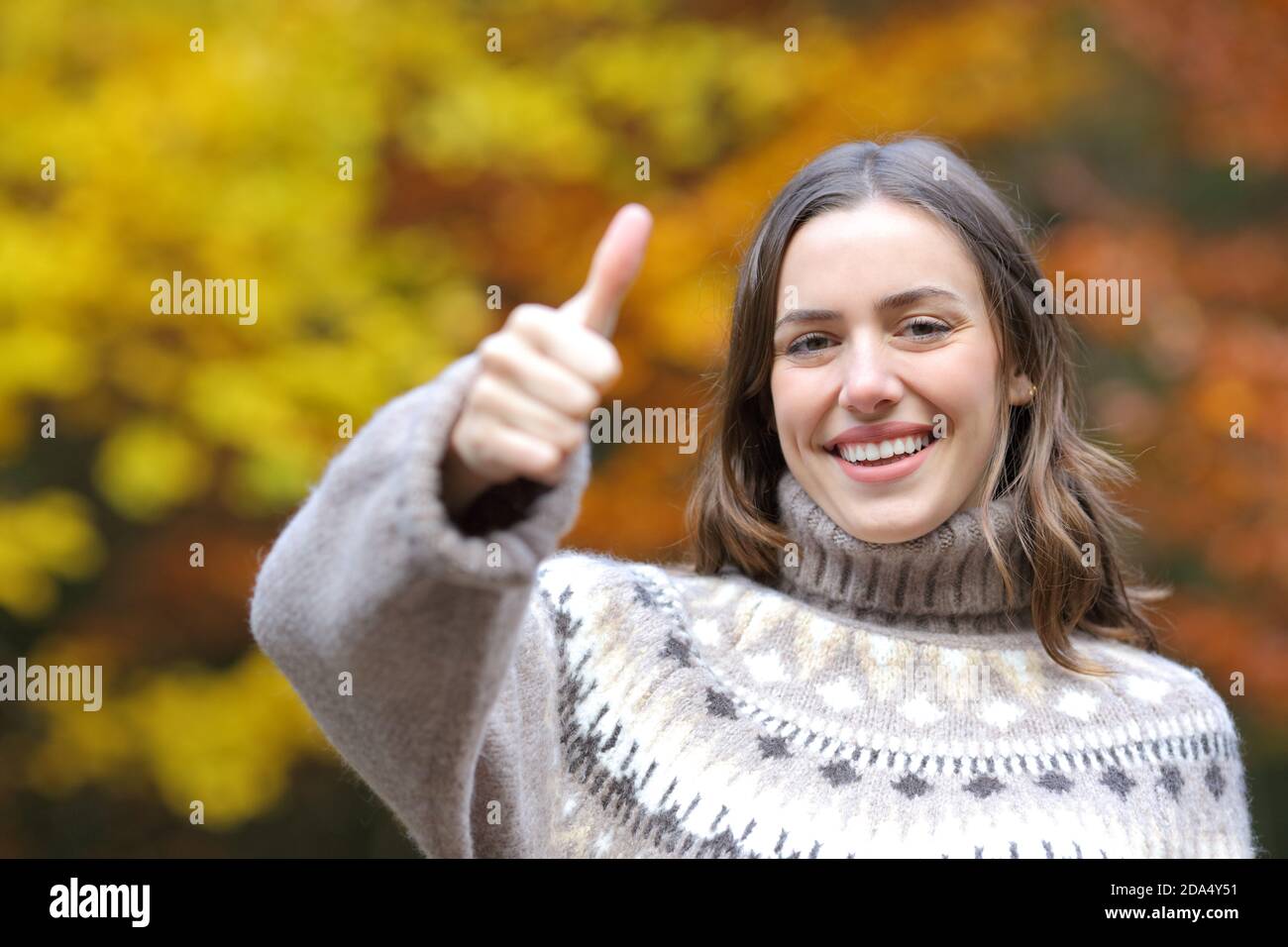 Vue avant d'une femme heureuse portant un chandail avec des pouces en automne Banque D'Images