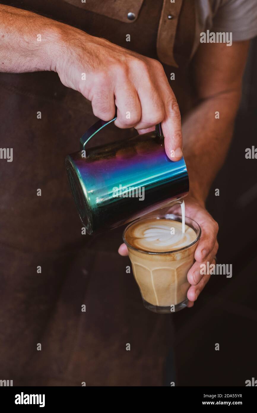 Gros plan sur le barista qui verse un café Latte. Banque D'Images