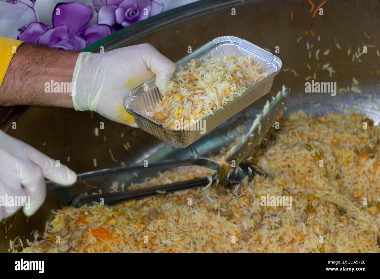 Chef mettant du riz cuit dans des assiettes. Cuisine traditionnelle turque: Pilav. Le concept de l'humanitarisme. Banque D'Images