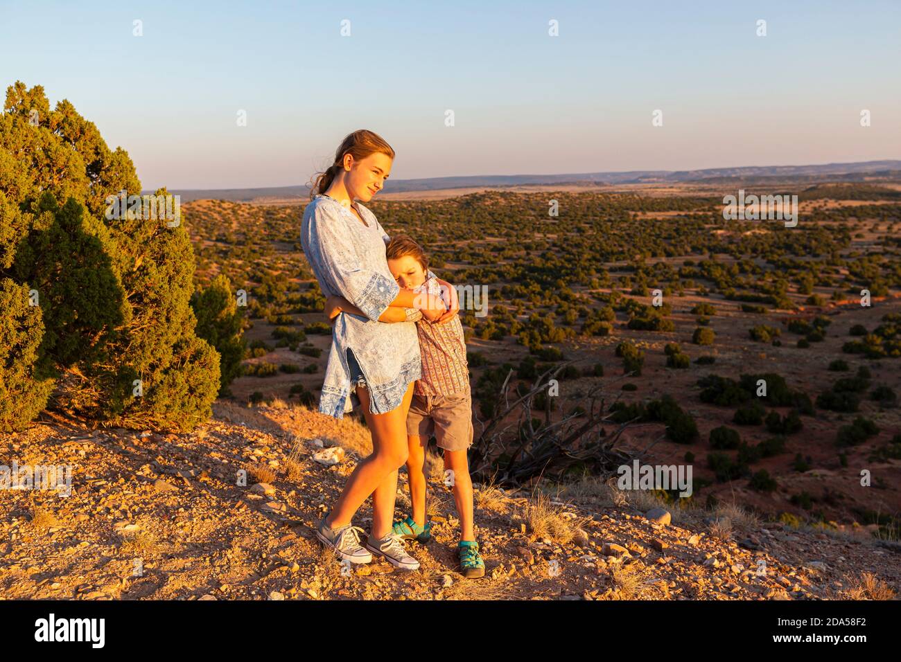 Jeune fille embrassant son frère cadet dans le bassin de Galisteo, Santa Fe, NOUVEAU-MEXIQUE. Banque D'Images