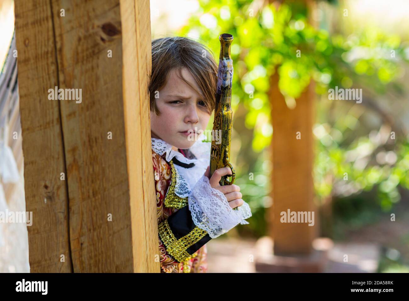 Jeune garçon habillé comme un pirate tenant un long pistolet. Banque D'Images