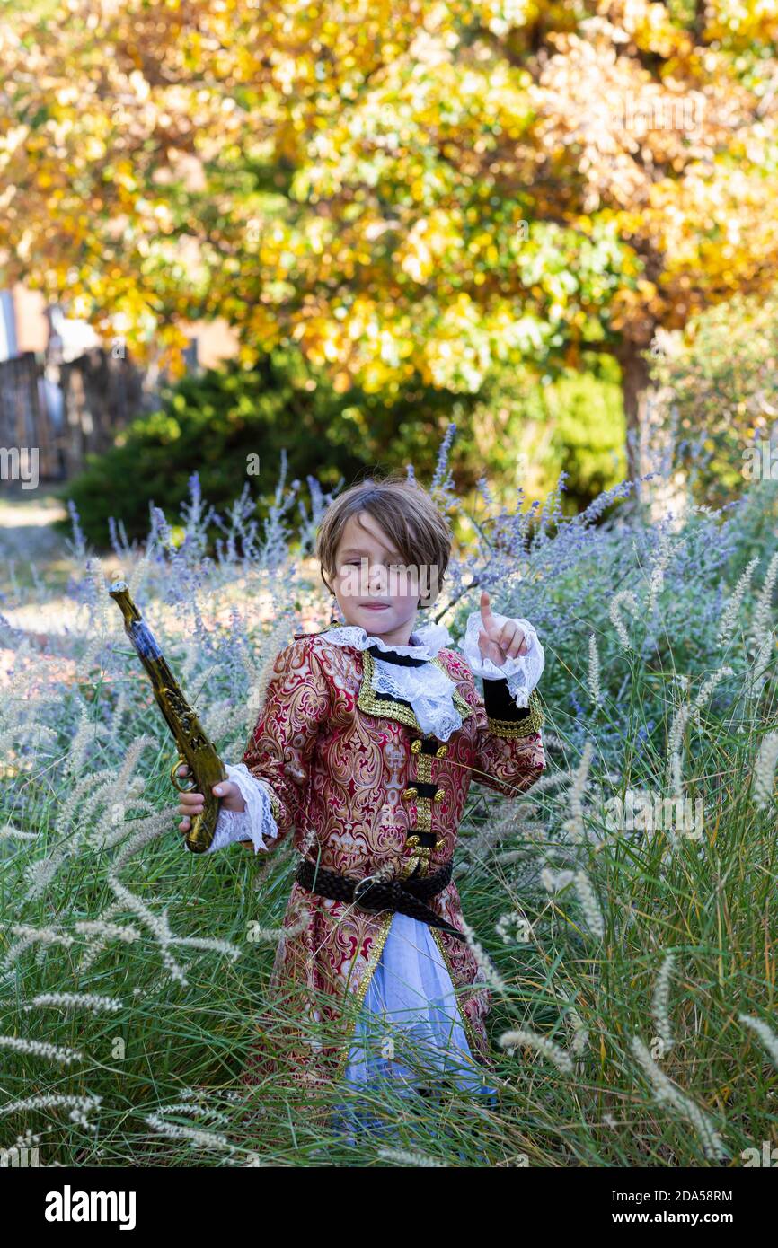 Jeune garçon habillé comme un pirate tenant un long pistolet. Banque D'Images