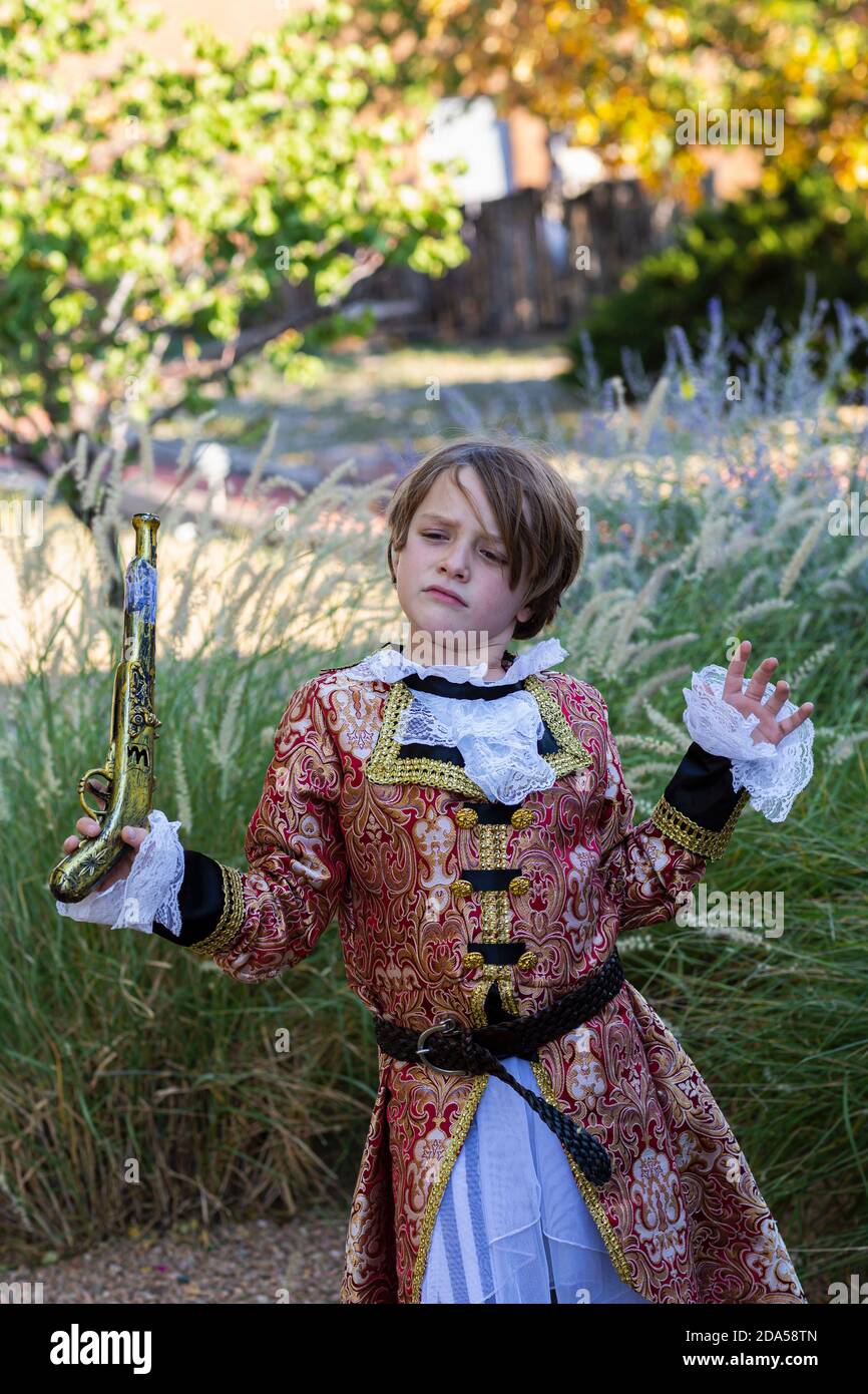 Jeune garçon habillé comme un pirate tenant un long pistolet. Banque D'Images