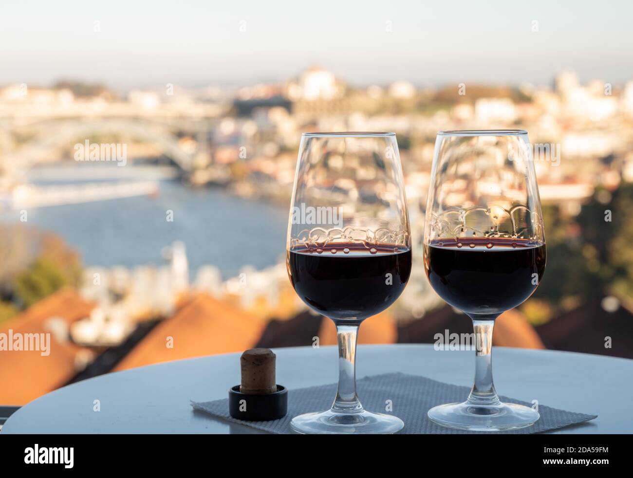 Dégustation de différents desserts fortifiés rubis, vins du port tawny en verres avec vue sur le Douro, les lodges de porto de Vila Nova de Gaia et la ville de Porto Banque D'Images