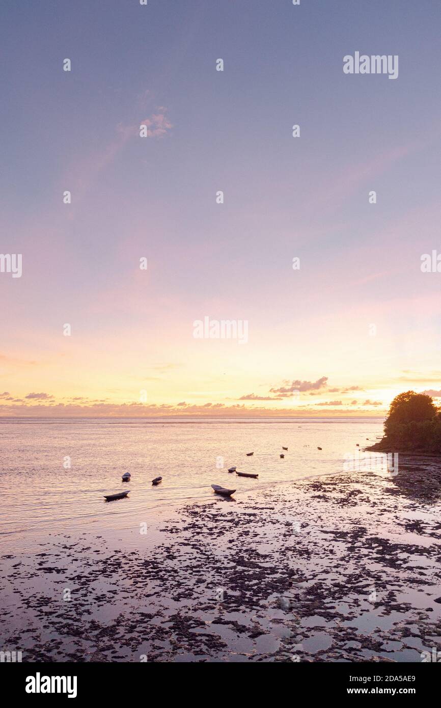 Vue sur la mer au coucher du soleil à Bali, avec lumière rose et beaucoup de petits bateaux de pêche pour la pêche de nuit Banque D'Images