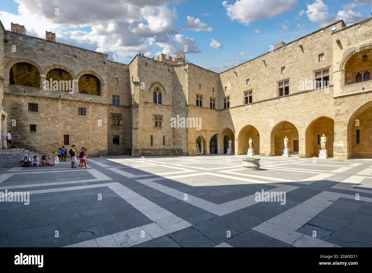 Les touristes se détendent à l'ombre dans la cour du Palais du Grand Maître des Chevaliers de Rhodes Sur l'île méditerranéenne de Rhodes Grèce Banque D'Images