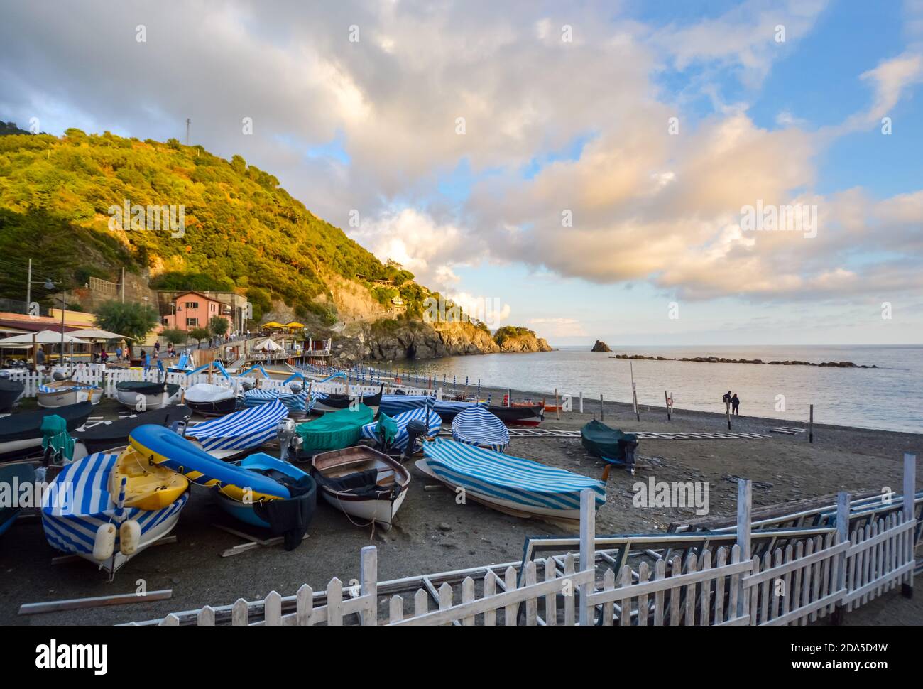 Tôt le matin sur un petit port dans le village italien de Monterosso al Mare, sur la côte ligurienne à Cinque Terre Italie avec des bateaux sur une plage de sable fin Banque D'Images