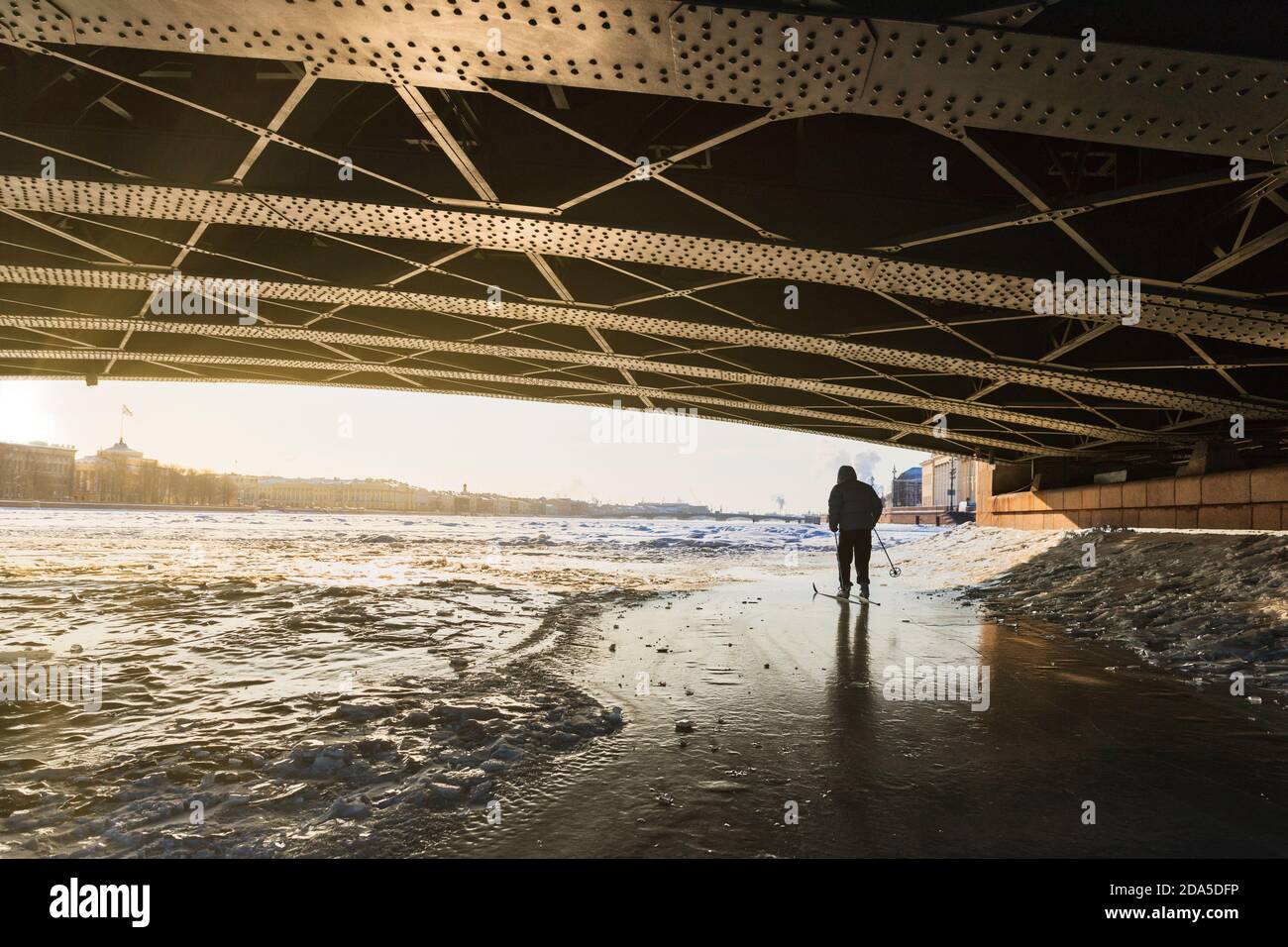 Silhouette de skieur sur glace de la Neva gelée Rivière sous le pont du Palais en hiver au coucher du soleil Banque D'Images