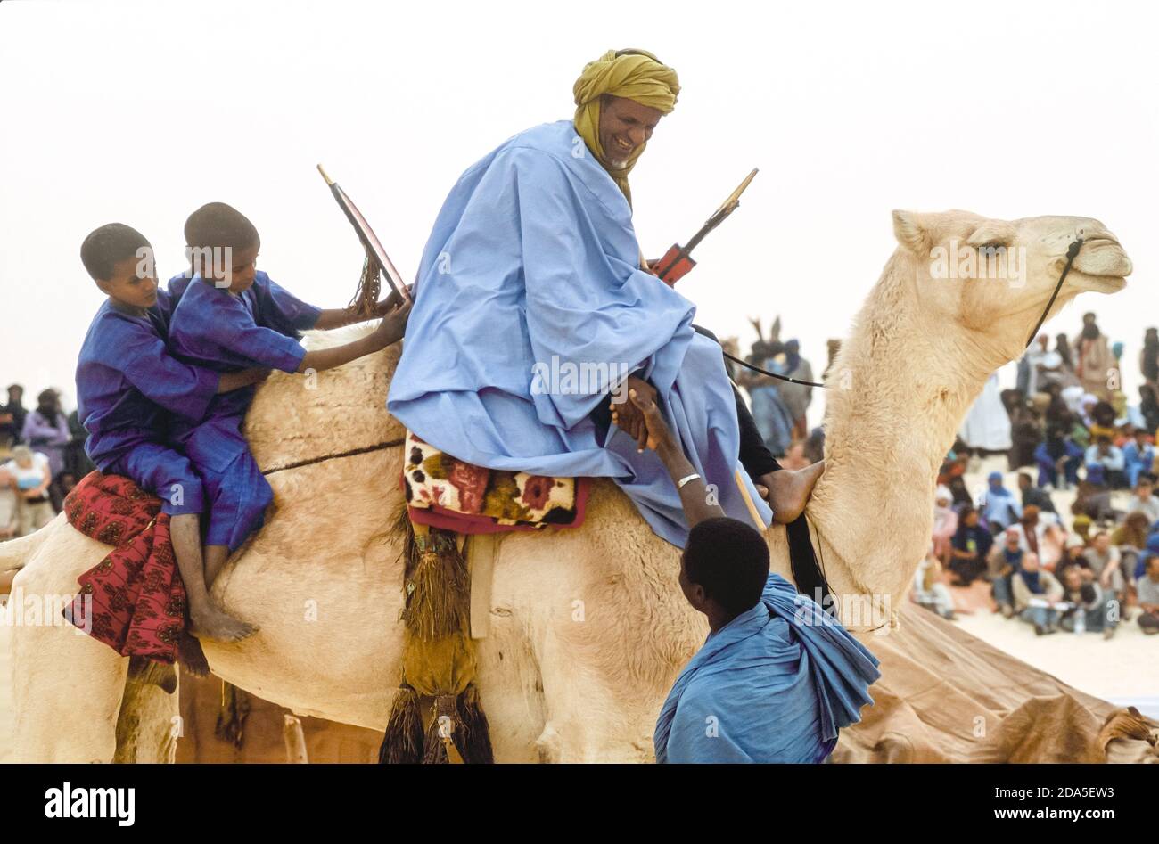 Afrique, Mali, Essakane, près de Tombouctou. Tuareg homme avec deux petits garçons sur son chameau saluant un ami. Festival dans le désert, Festival au désert 2005 Banque D'Images