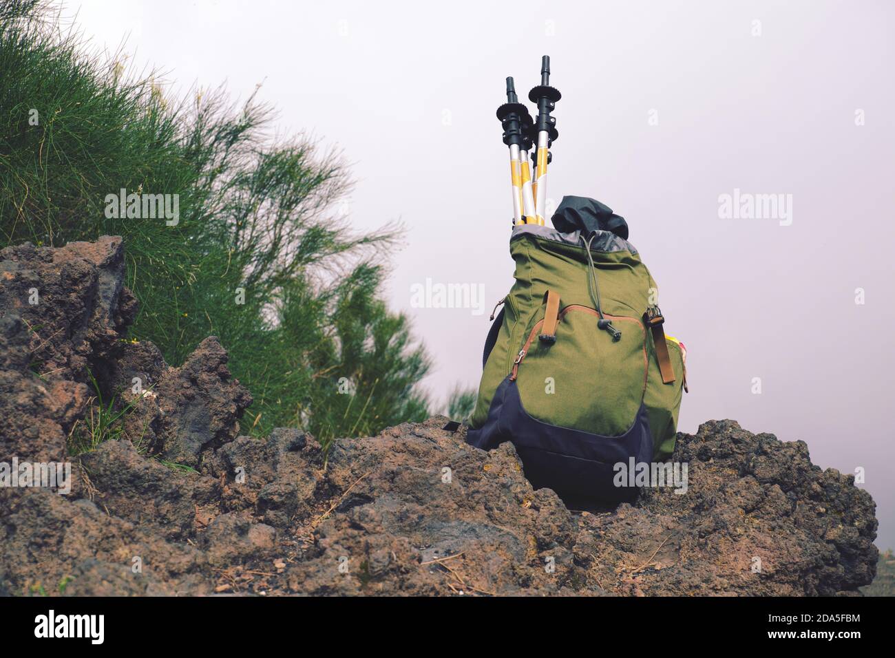 Sac à dos avec bâtons de randonnée sur la roche volcanique dans le parc de l'Etna, Sicile Banque D'Images
