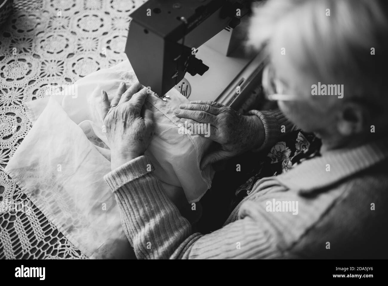 Vue de dessus d'une image en noir et blanc d'un retiré grand-mère caucasienne qui se rase sur une machine à coudre Banque D'Images