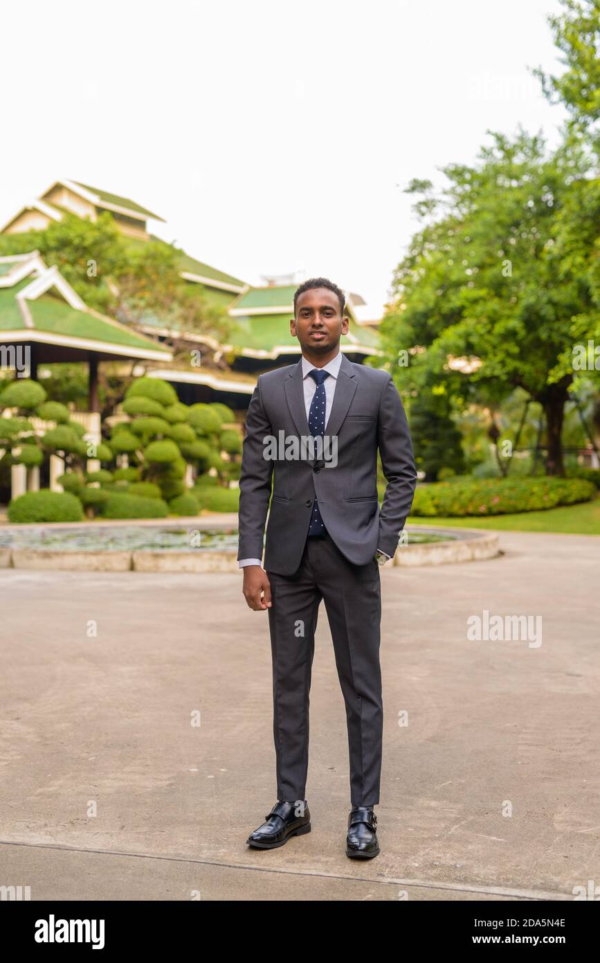 Portrait d'un jeune homme d'affaires africain charmant debout à l'extérieur Banque D'Images
