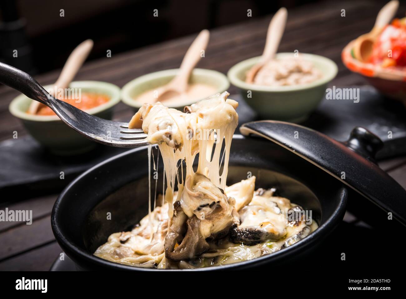 Fondou au fromage de champignons avec trempettes en arrière-plan Banque D'Images