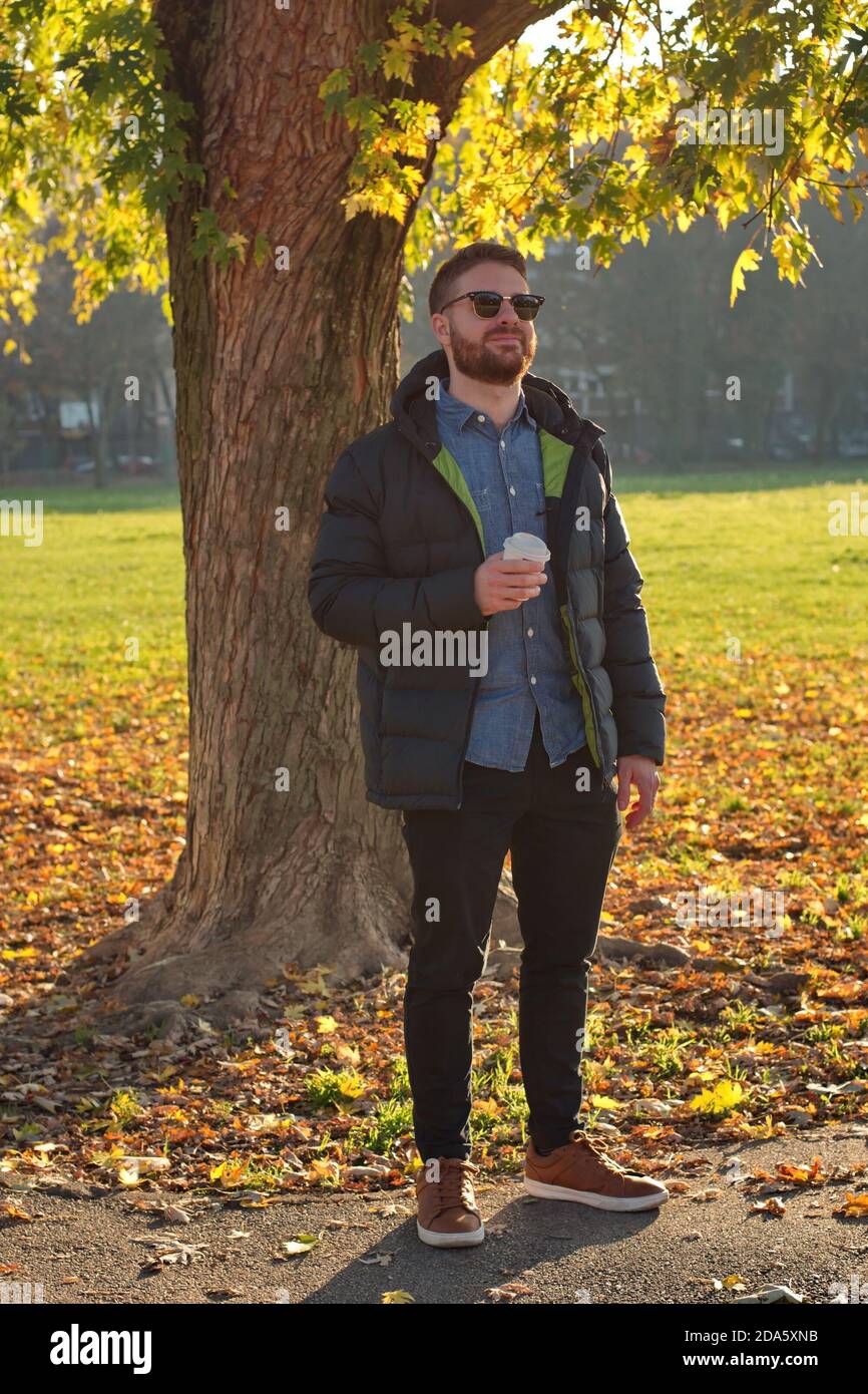 Portrait de beau jeune homme dans le parc - paysage d'automne Banque D'Images