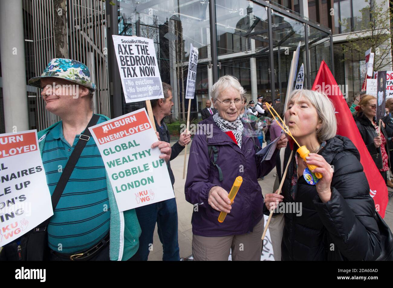 Manifestation pour marquer le premier anniversaire de la « taxe de chambre », devant One Hyde Park, l'une des résidences les plus chères de Londres. La loi de 2012 sur la réforme du bien-être social, entrée en vigueur le 1er avril 2013, comprenait des modifications aux règles sur les prestations de logement. Ces changements comprennent une « pénalité de sous-occupation » qui réduit le montant de l'avantage versé aux demandeurs s'ils sont considérés comme ayant trop d'espace de vie dans la propriété sur laquelle ils demandent une prestation de logement, ces changements sont devenus la « taxe de chambre ». One Hyde Park, Knightsbridge, Londres, Royaume-Uni. 5 avril 2014 Banque D'Images