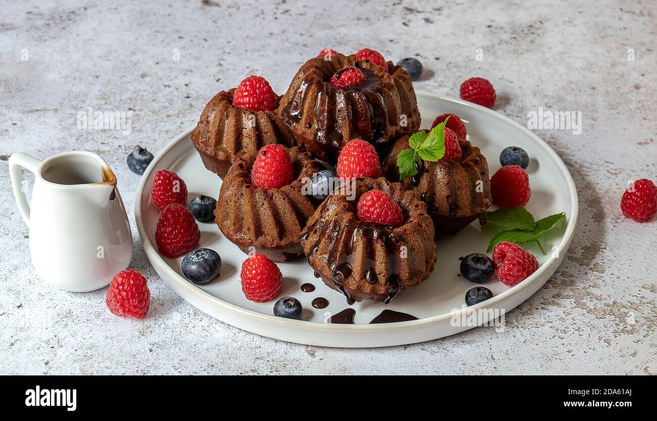 Petits gâteaux au chocolat avec chocolat et baies fraîches Banque D'Images