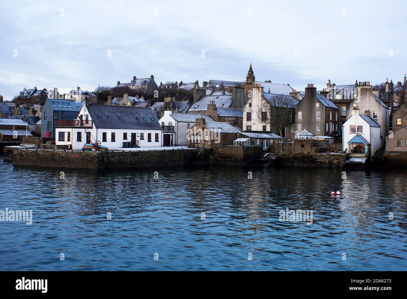 Scène d'hiver dans la ville écossaise au bord de l'eau avec des maisons couvertes Neige sur les îles Orcades Banque D'Images