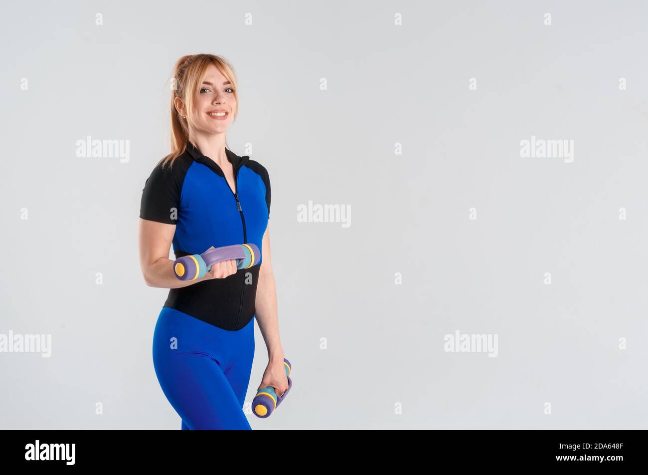 Femme avec corps en ABS slim fit haltère isolé sur un fond blanc. Mode de vie sain. Banque D'Images