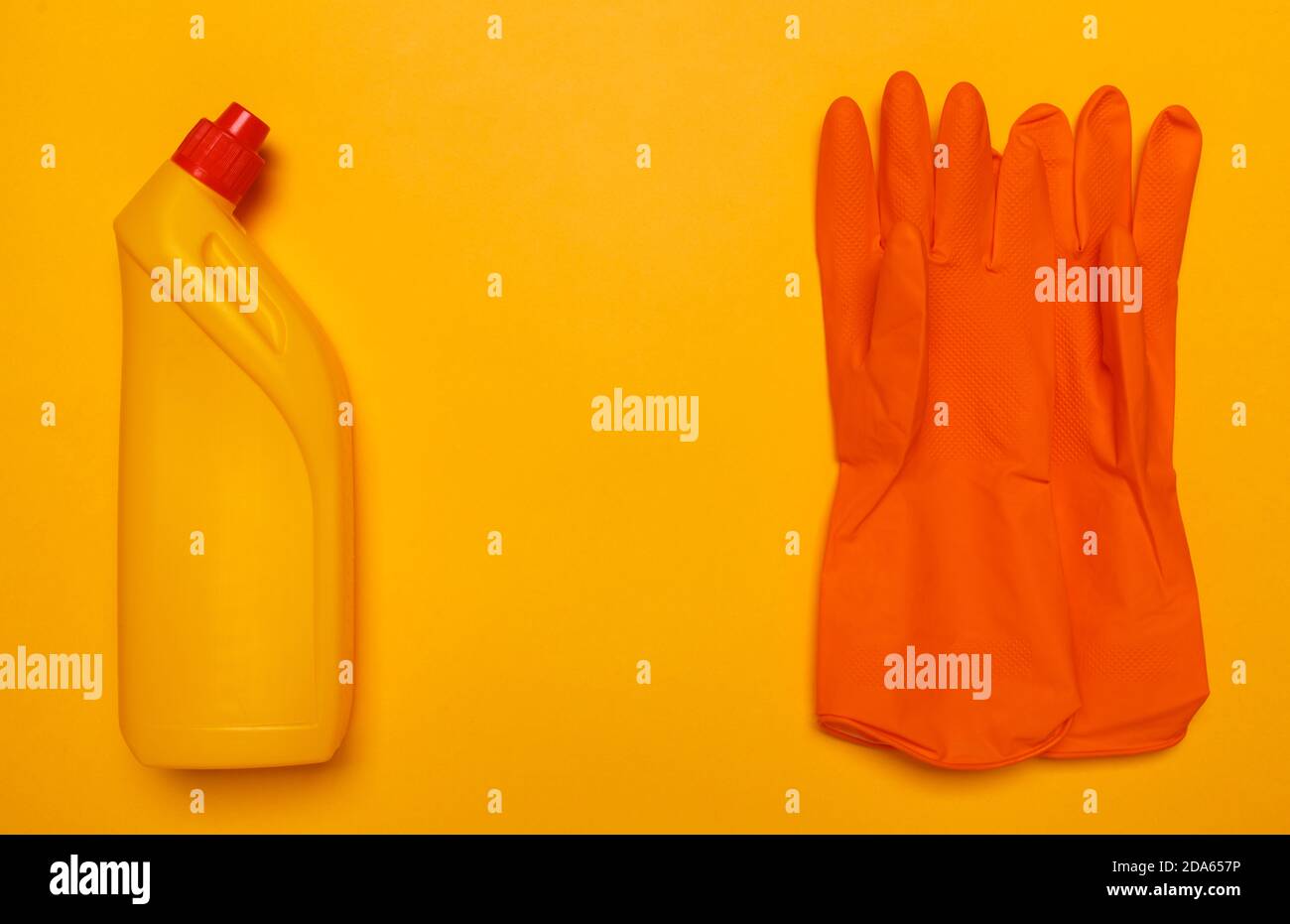 bouteille de toilette jaune et gants en caoutchouc orange. Banque D'Images