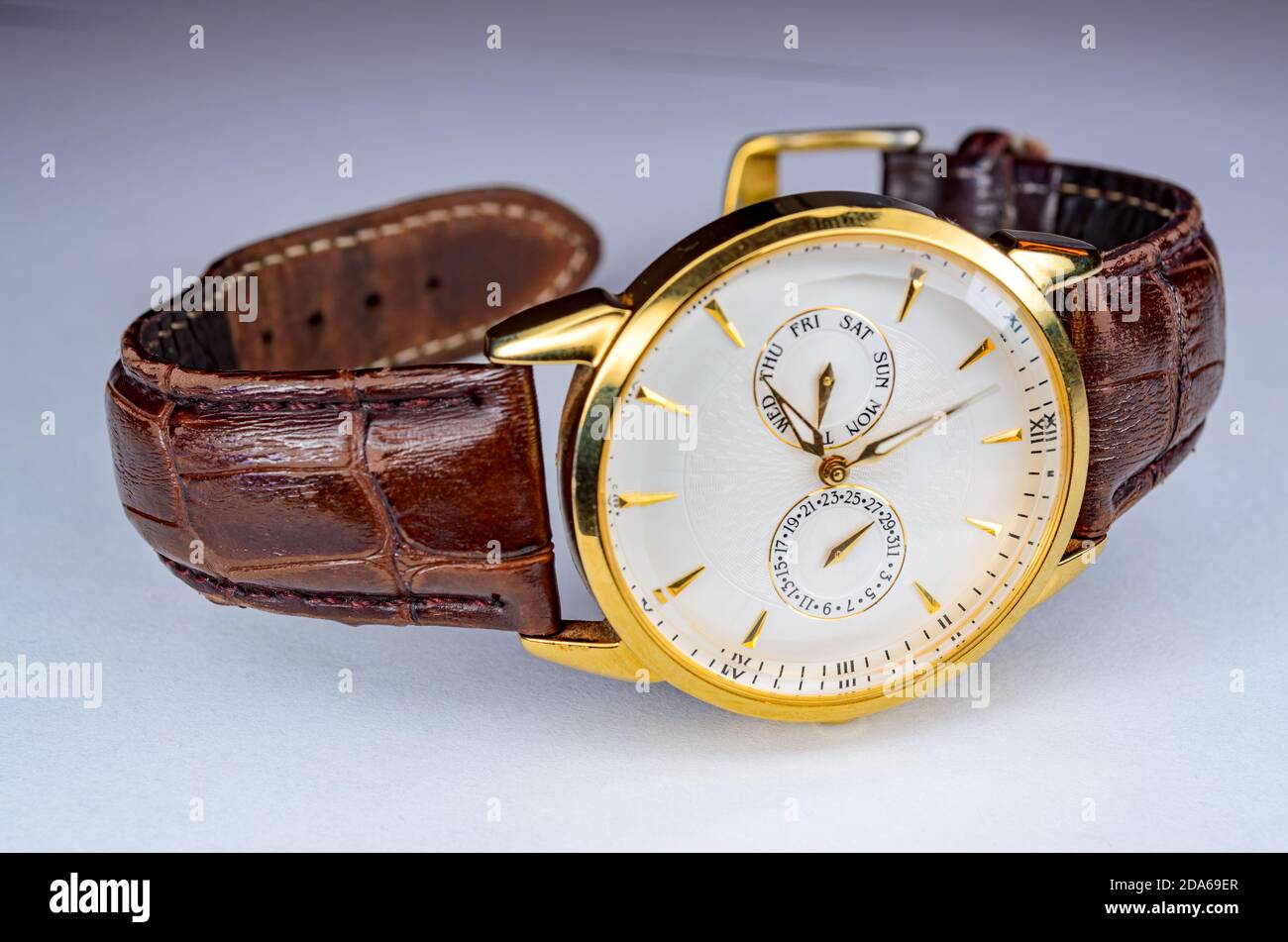 Élégante montre Gold avec ceinture en cuir marron légèrement usée Banque D'Images