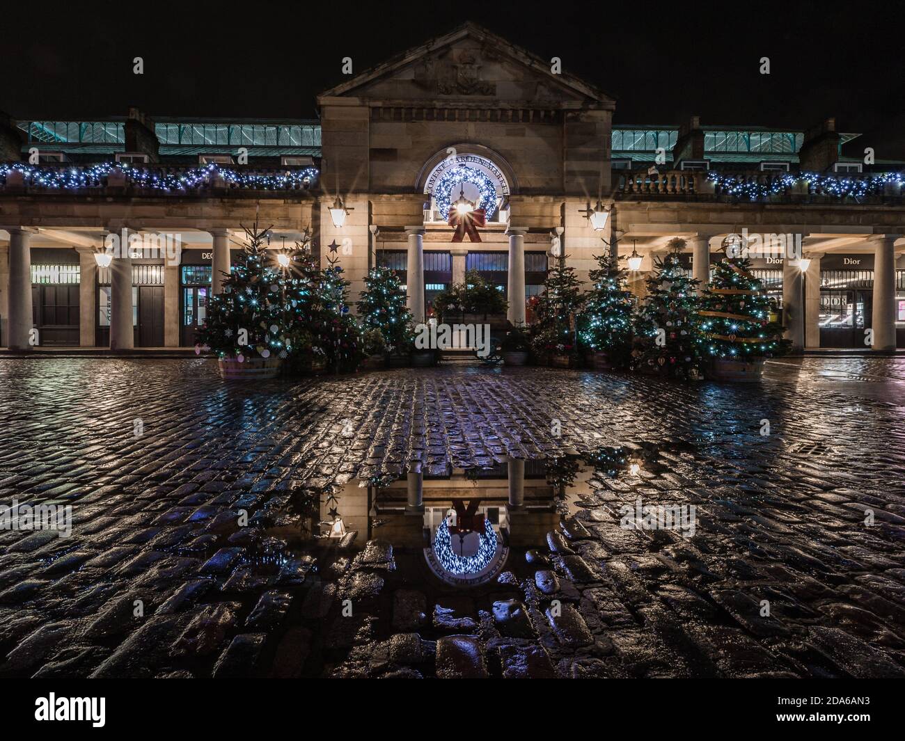 Pluie et réflexions à la tombée de la nuit autour de l'arbre de noël à Covent Garden pendant le deuxième confinement à Londres. Banque D'Images