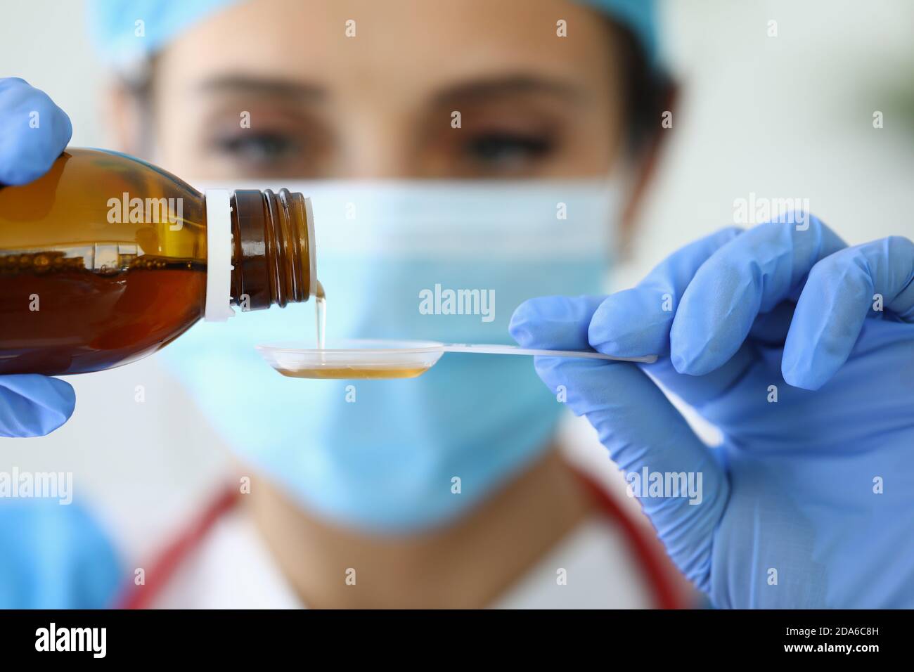 Le médecin verse des médicaments dans une cuillère de mesure Banque D'Images