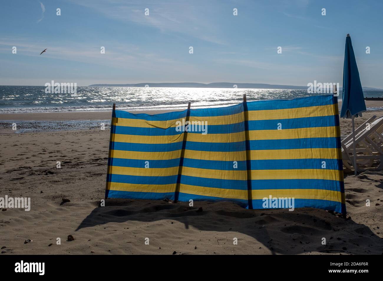 Une pause-vent à rayures bleues et jaunes sur la plage de Boscombe qui est une partie de la célèbre plage de sable de sept kilomètres à Bournemouth et Poole à Dorset. 28 septembre 2015. Photo: Neil Turner Banque D'Images