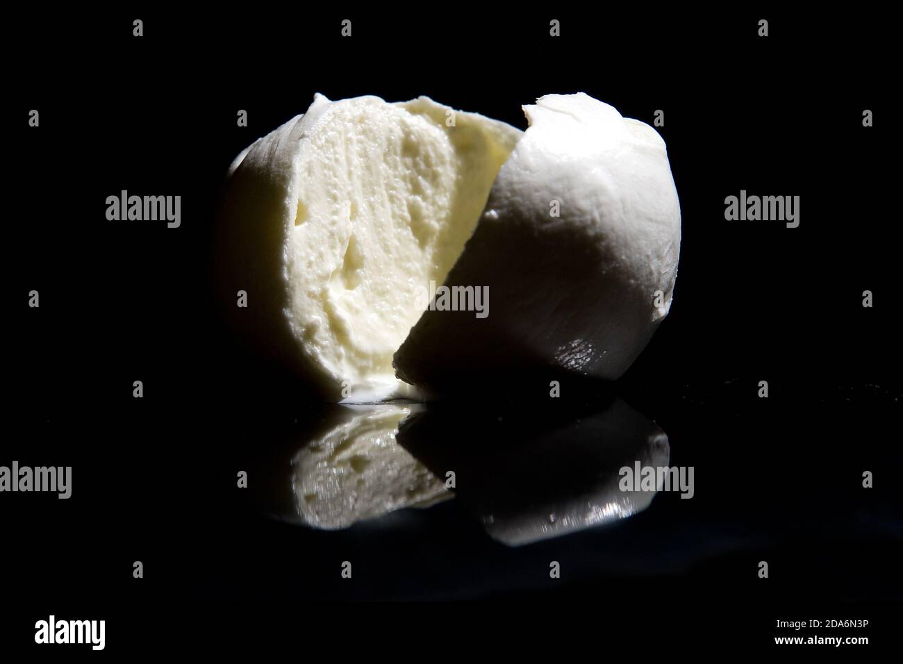 Fromage mozzarella de buffle italien de la région de Campanie en Italie sur fond noir miroir avec lumière de découpe Banque D'Images