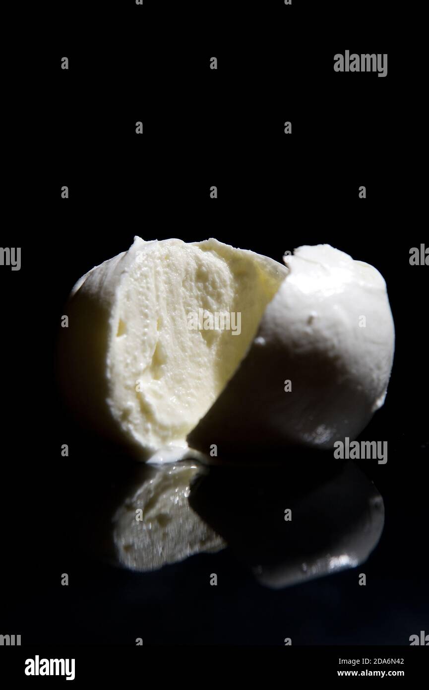 Fromage mozzarella de buffle italien de la région de Campanie en Italie sur fond noir miroir avec lumière de découpe Banque D'Images