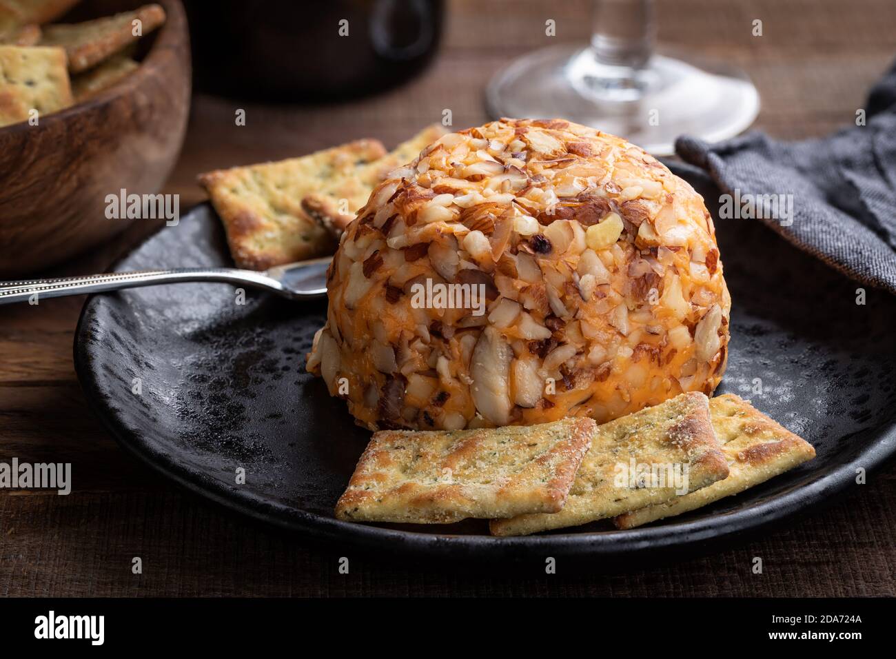 Boule de fromage cheddar et craquelins sur une assiette noire Banque D'Images