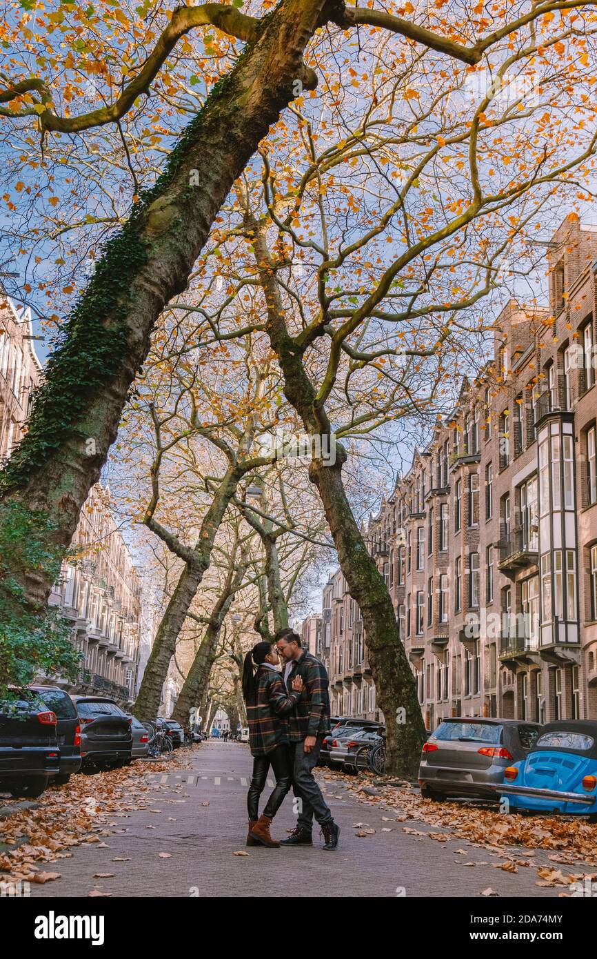 Amsterdam pays-Bas pendant la saison d'automne , couple hommes et femme  visitent la ville d'Amsterdam avec des couleurs orange le long du canal en  octobre Photo Stock - Alamy