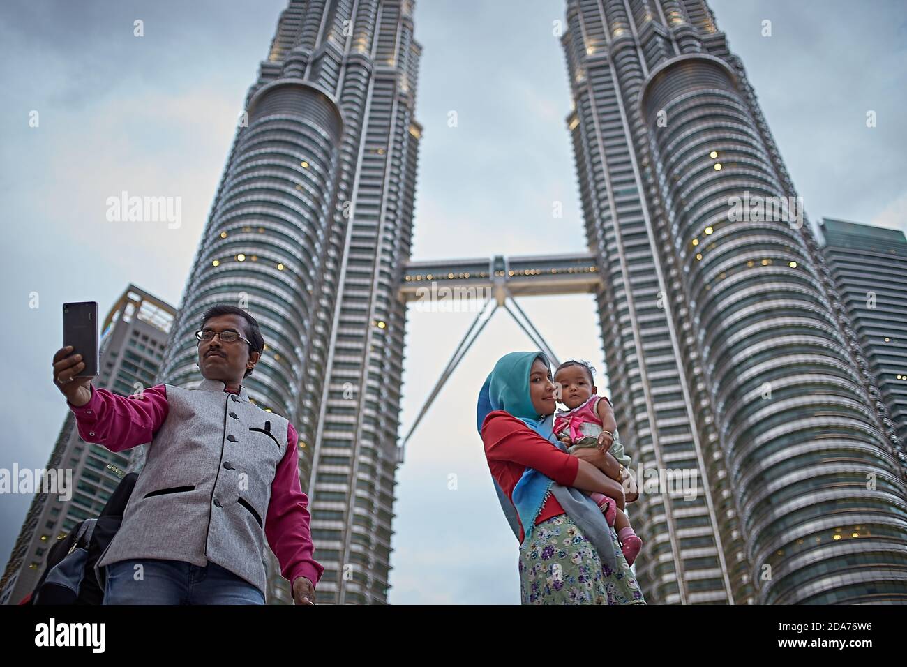 Kuala Lumpur, Malaisie, février 2016. Une famille faisant un selfie avec les tours Petronas derrière eux. Banque D'Images