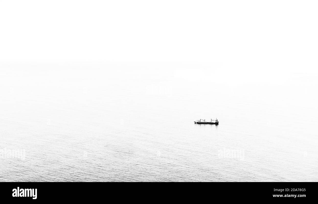 Cargo attendant au milieu de la mer bleue Banque D'Images