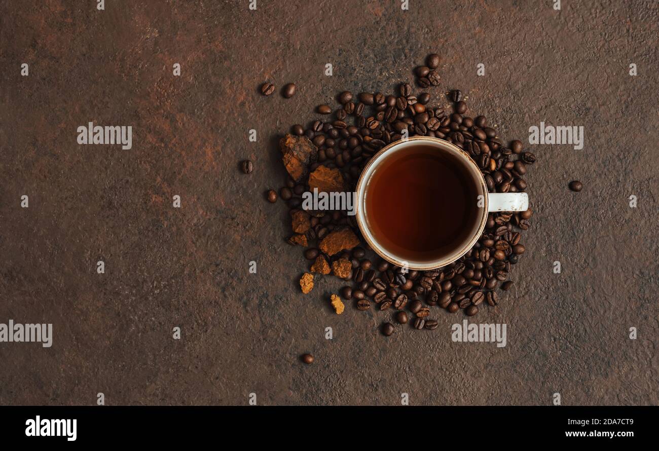 Boisson à base de chaga aux champignons avec café sur fond brun foncé. Super-cuisine tendance. Espace de copie, vue de dessus, Flat lay. Banque D'Images