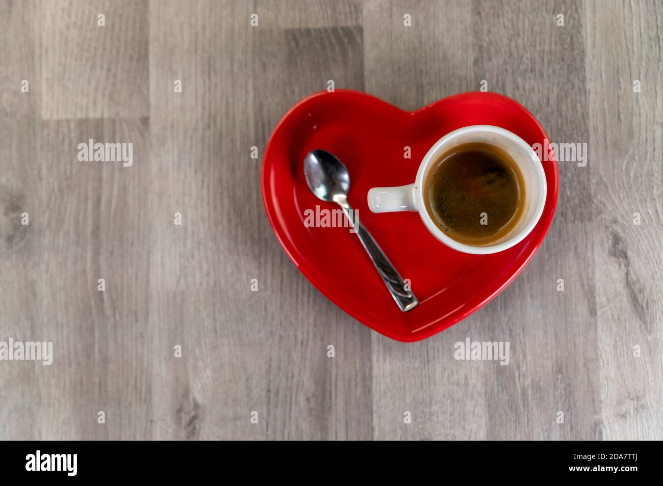 une tasse de café avec une soucoupe en forme de coeur et un cuillère à café Banque D'Images