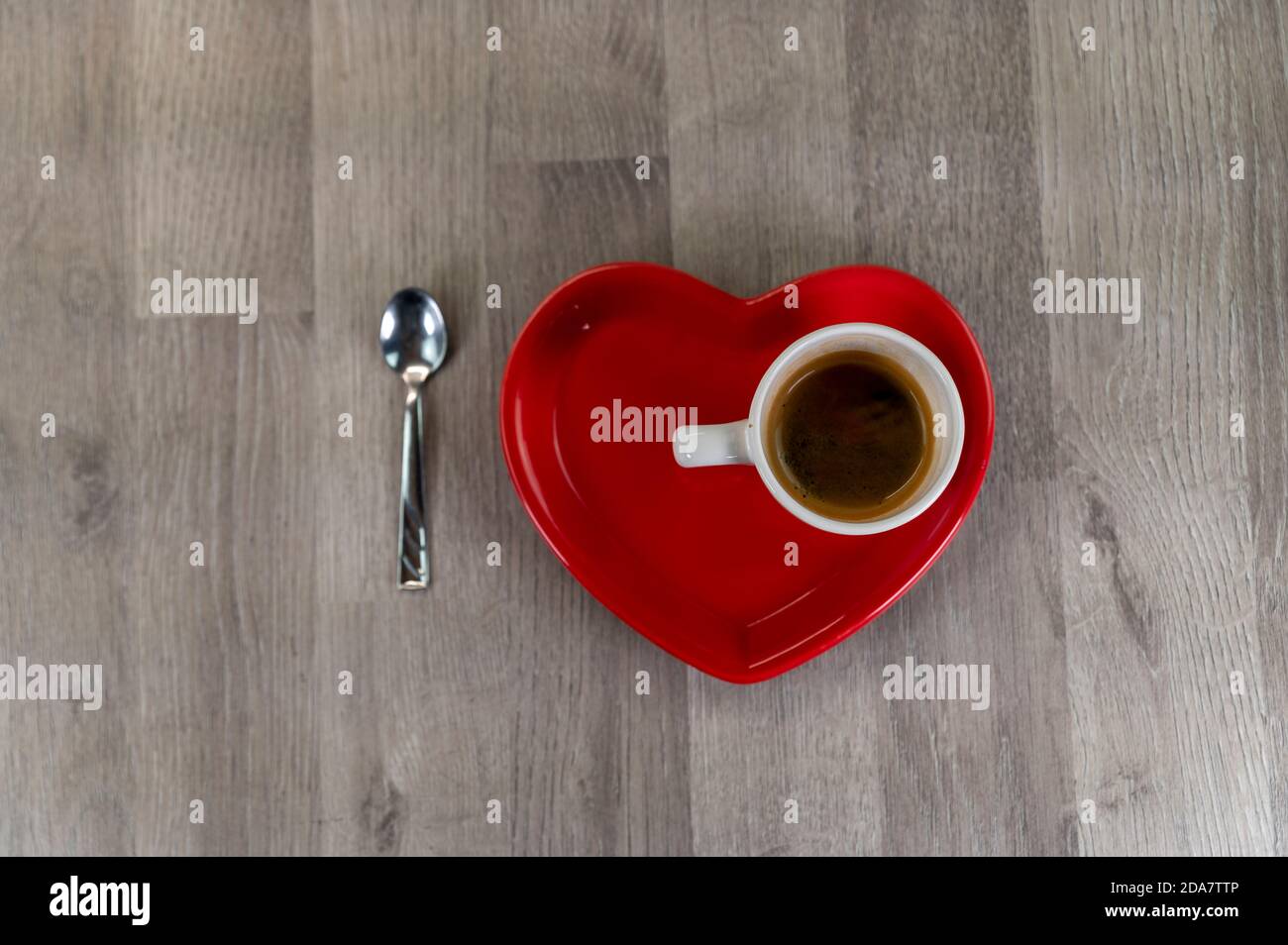 une tasse de café avec une soucoupe en forme de coeur et un cuillère à café Banque D'Images