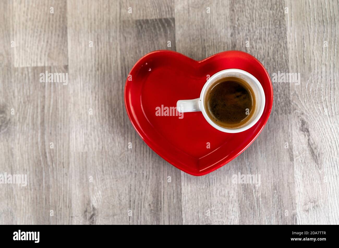 une tasse de café avec une soucoupe en céramique rouge à coeur Banque D'Images