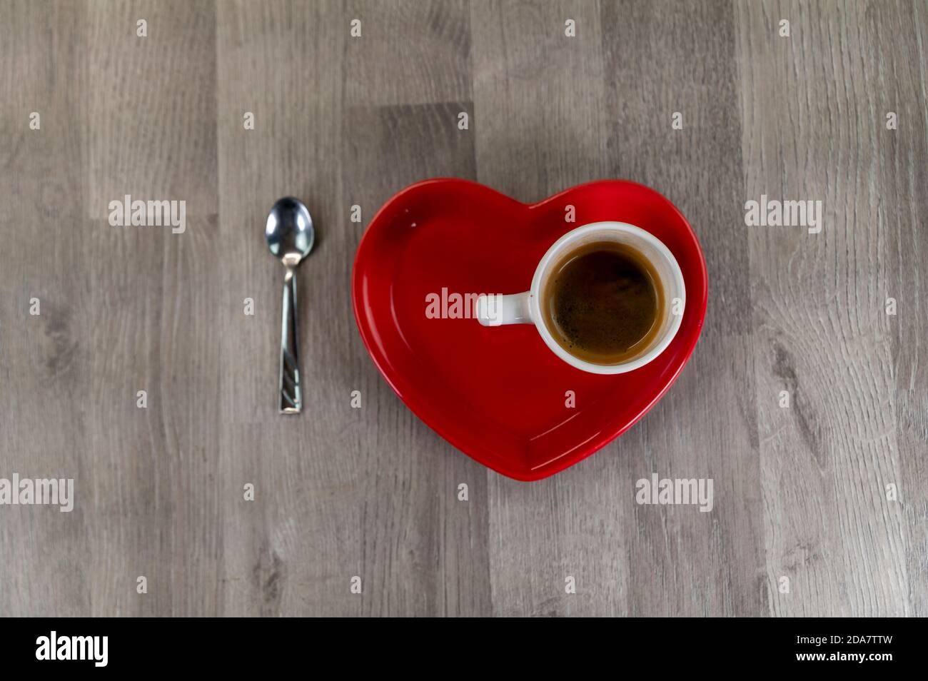 une tasse de café avec une soucoupe en forme de coeur et un cuillère à café Banque D'Images