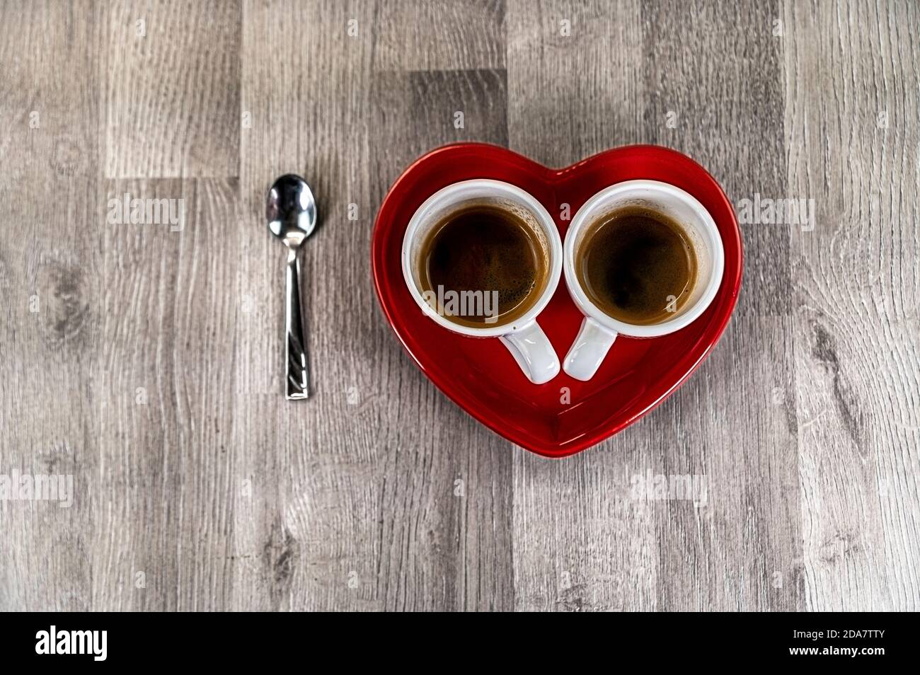 deux cuillères à café avec une soucoupe en forme de cœur et un cuillère à café Banque D'Images
