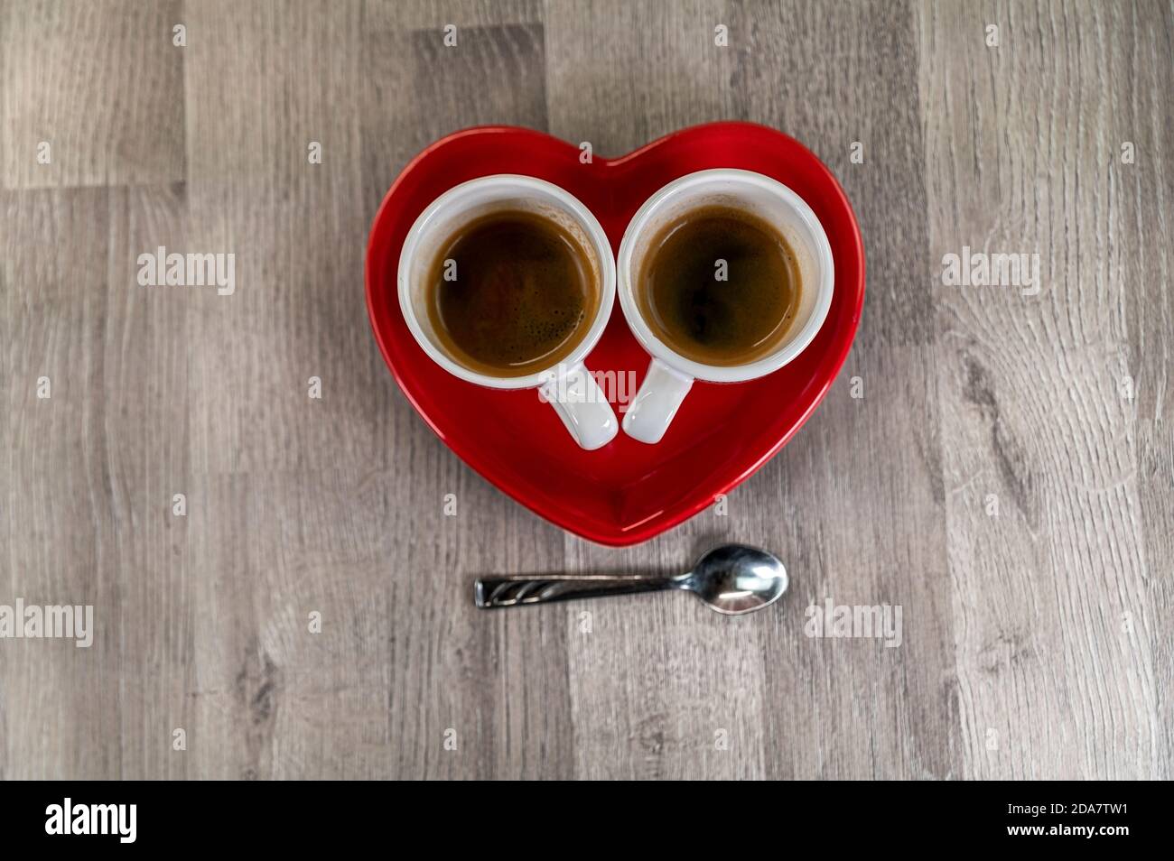 deux cuillères à café avec une soucoupe en forme de cœur et un cuillère à café Banque D'Images
