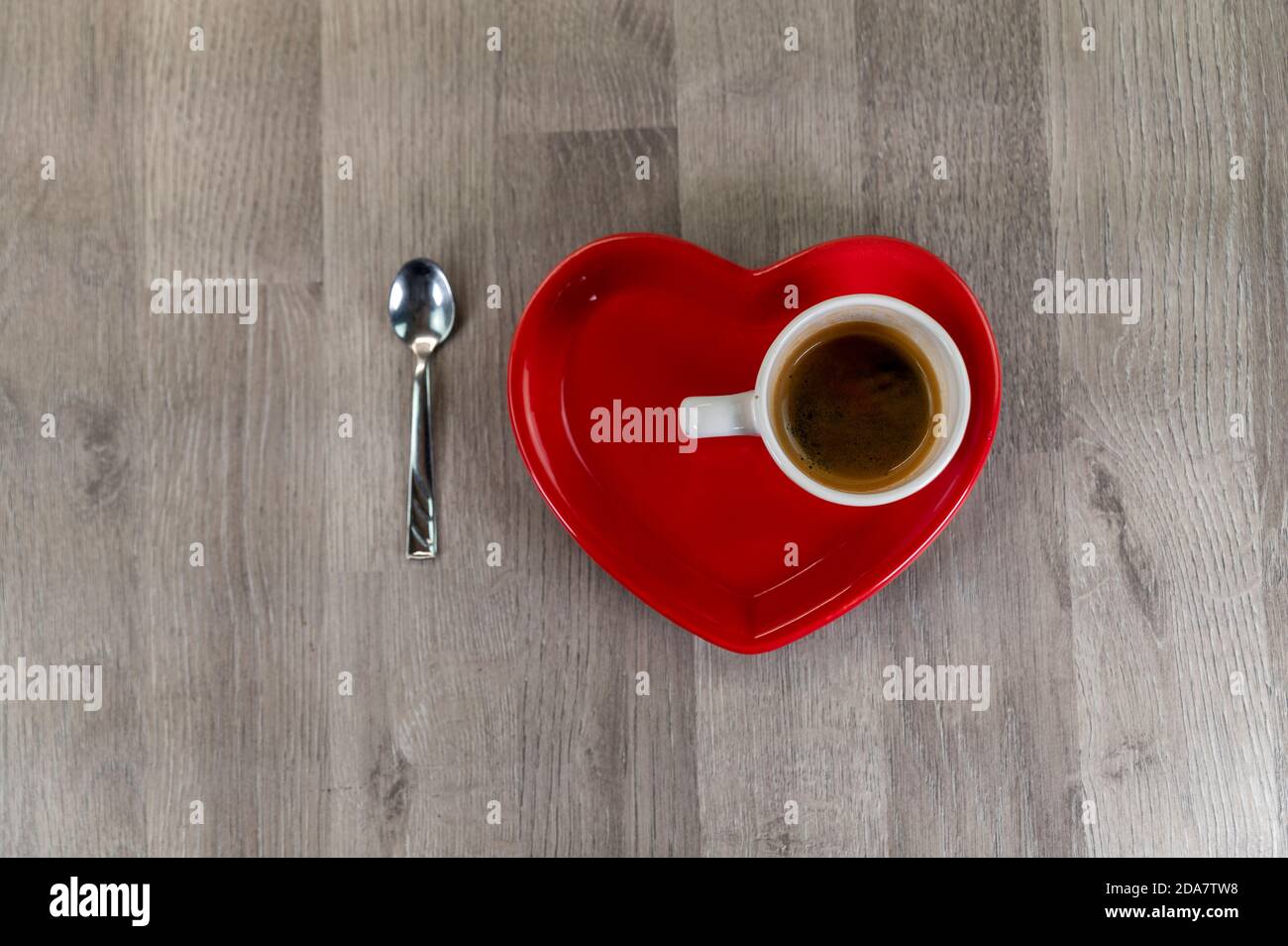 une tasse de café avec une soucoupe en forme de coeur et un cuillère à café Banque D'Images