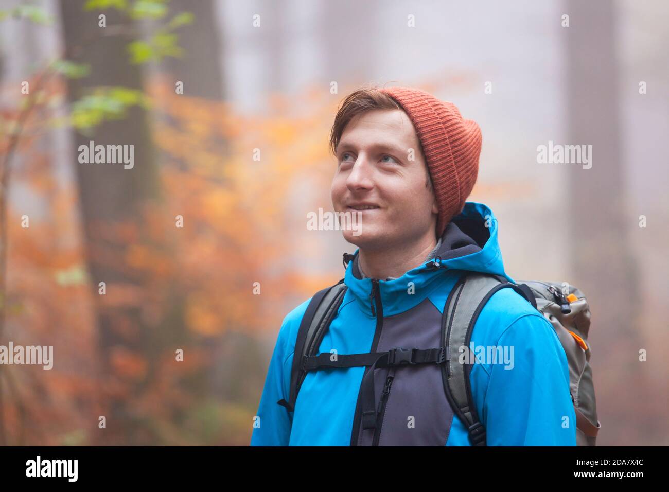 Jeune homme randonnée avec sac à dos dans une forêt en automne - se concentrer sur le visage Banque D'Images