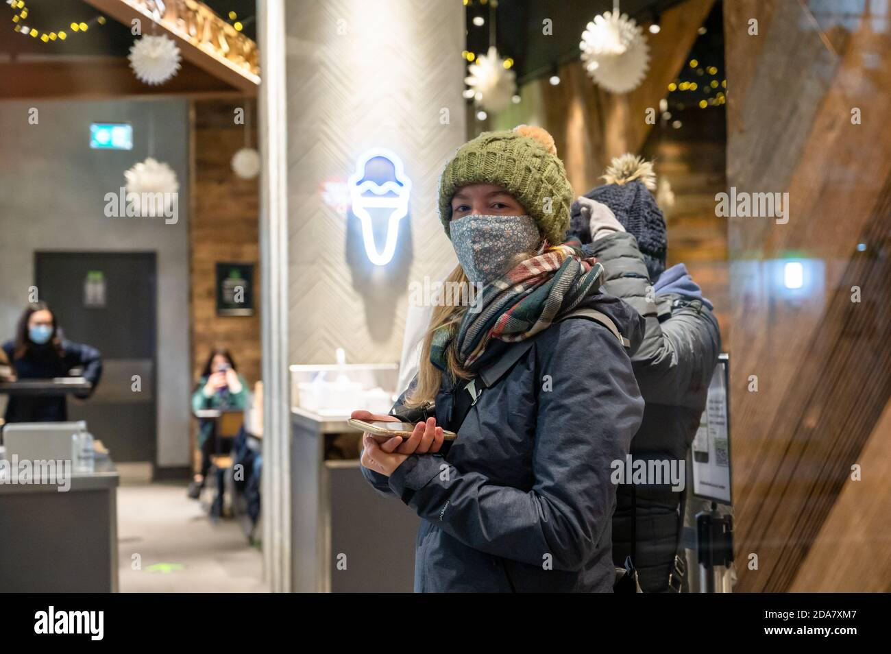 LONDRES - 3 NOVEMBRE 2020 : deux femmes portent un masque facial en attendant de prendre une commande alimentaire dans un restaurant pendant la pandémie de Covid Banque D'Images