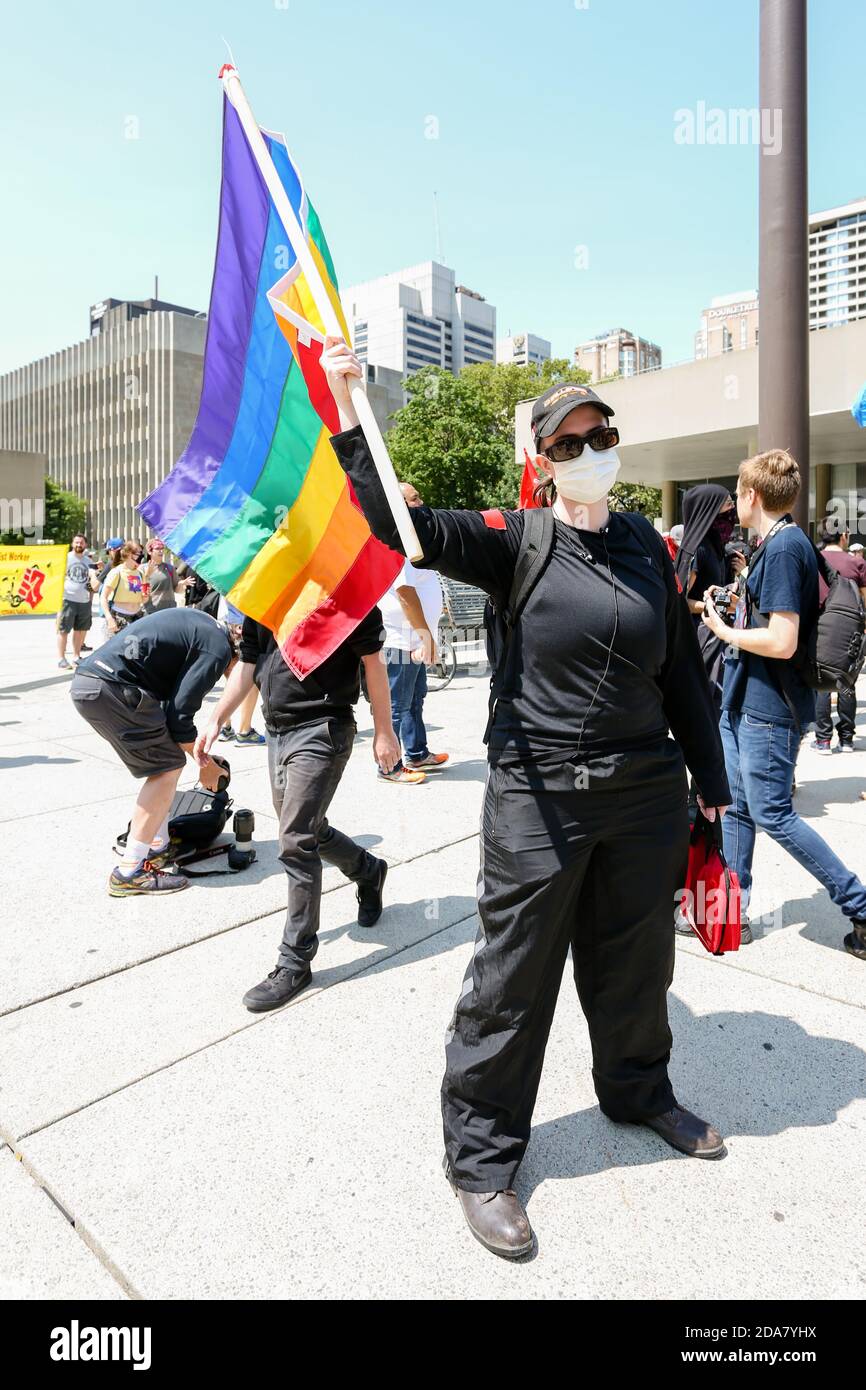 Un manifestant masqué a tenu un drapeau arc-en-ciel LGBTQ pendant la manifestation.UN rassemblement 'Stop the Hate' a été organisé par des manifestants anti-fascistes de l'ANTIFA à Nathan Phillip Square, en opposition à WCAI (Coalition mondiale contre l'Islam) Canada, un groupe qui a organisé une manifestation le même jour. Banque D'Images